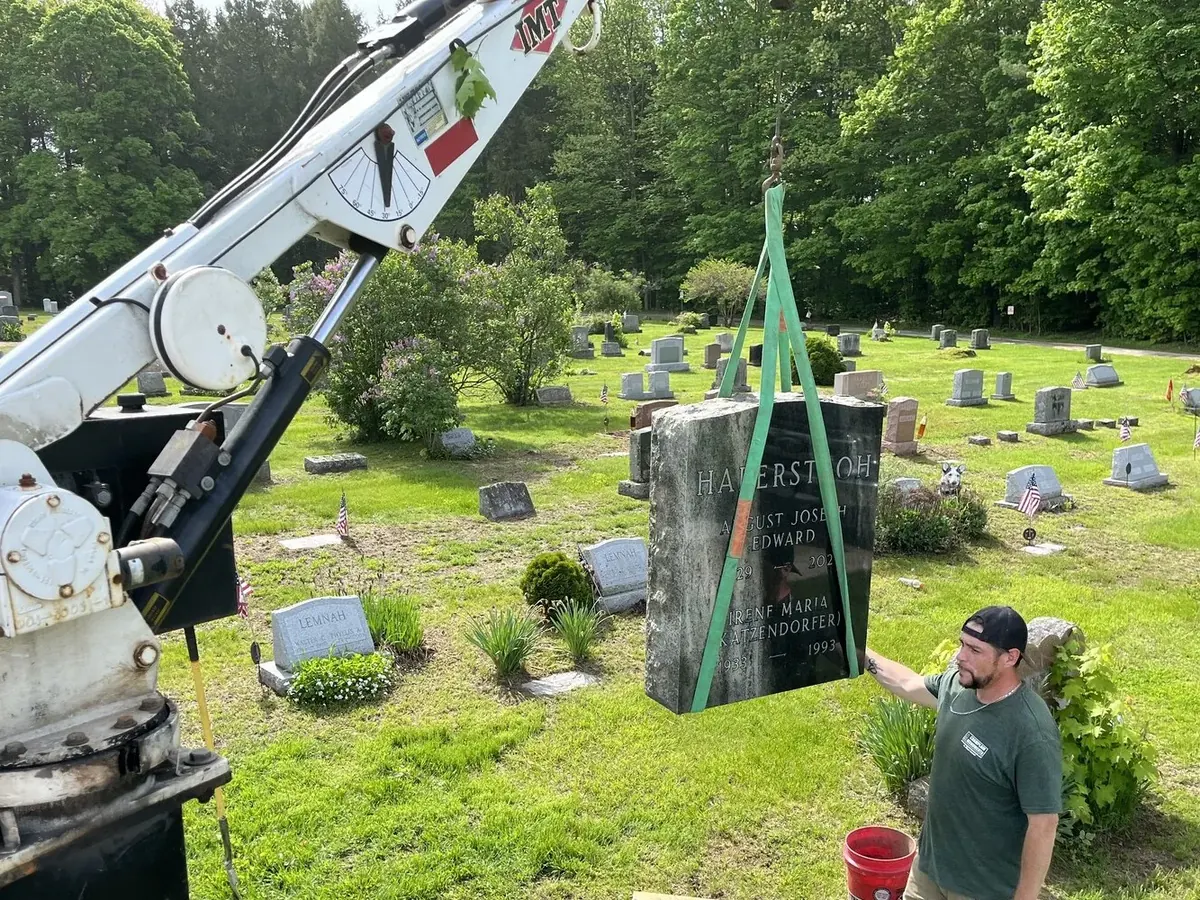 A crane setting a new monument in a cemetery